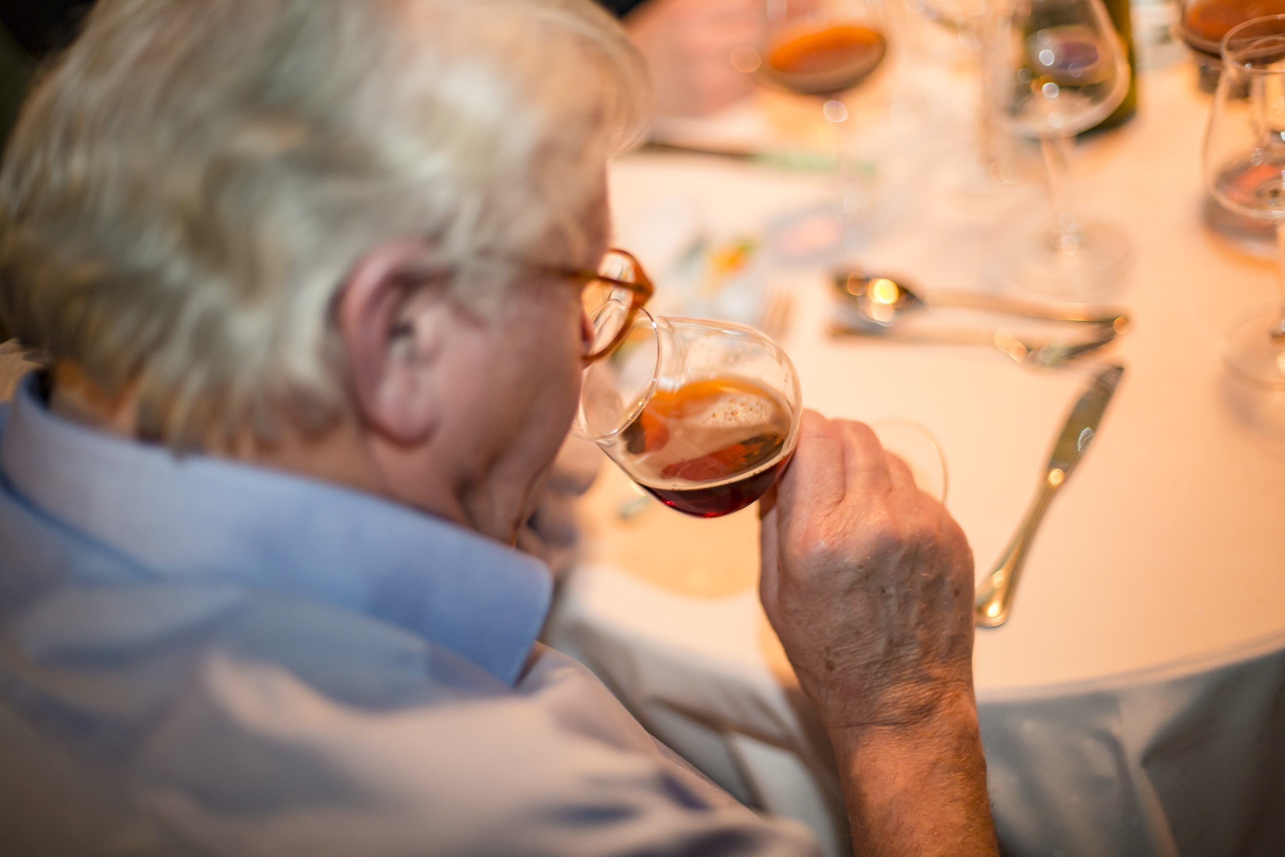 Gast riecht bei einer Bierverkostung bewusst an einem Bier im Verkostungsglas