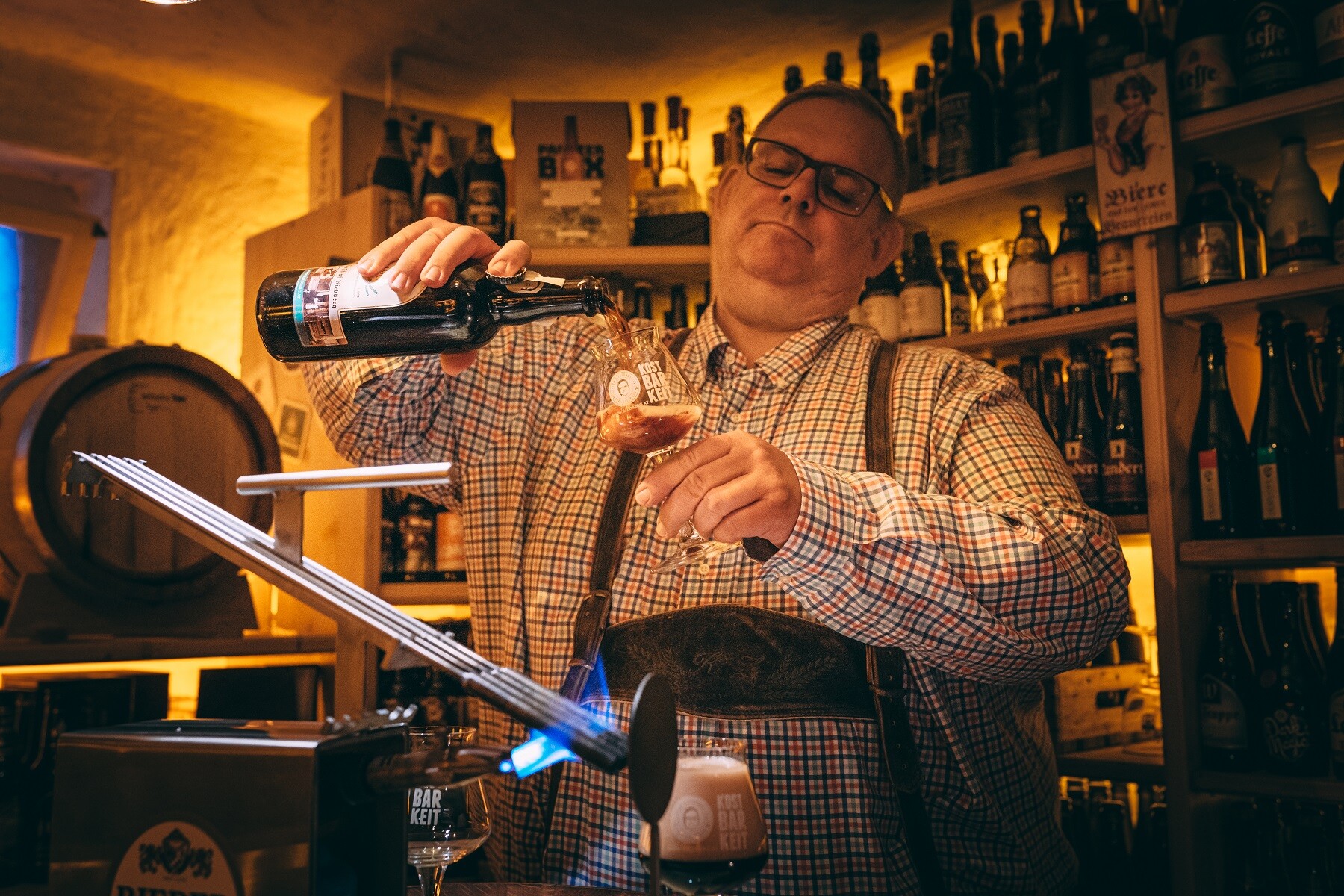Biersommelier beim Bierstacheln mit glühendem Eisen im Bierkeller des Biergasthof Riedberg